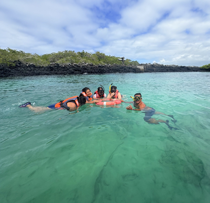 Grupo de pessoas se preparando para fazer mergulho com snorkel com uma bóia vermelha no mar.