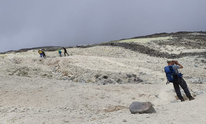 Pessoas caminhando até as minas de enxofre do vulcão Sierra Negra.